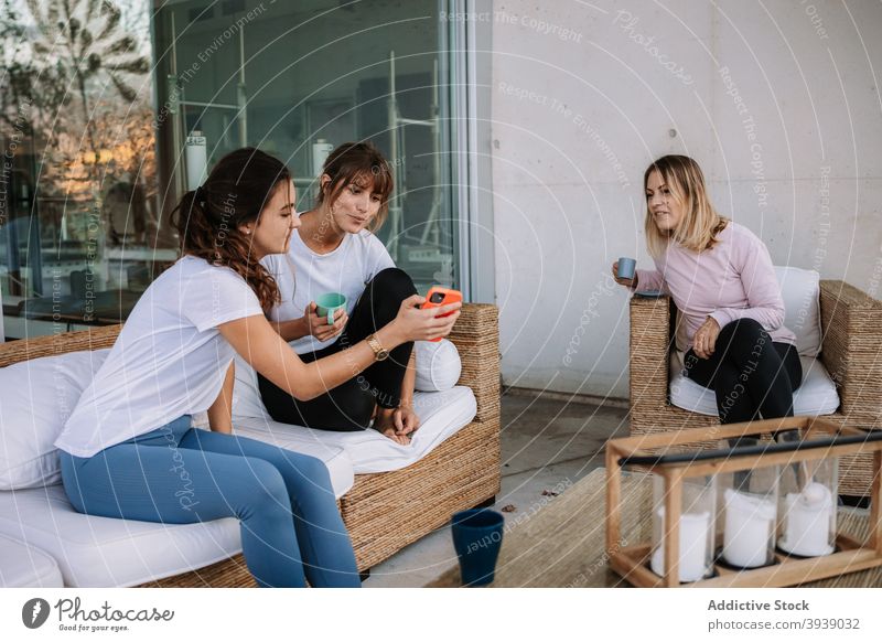 Gesellschaft von Frauen entspannen zusammen auf der Terrasse Unternehmen Freund sich[Akk] entspannen Smartphone zuschauen Video Freundschaft sich[Akk] sammeln