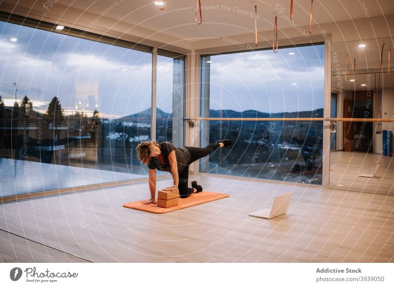 Frau macht Yoga in Plank auf dem Knie Pose und beobachten Tutorial Laptop üben Asana Schiffsplanken Gleichgewicht Atelier Video Lektion Wohlbefinden passen