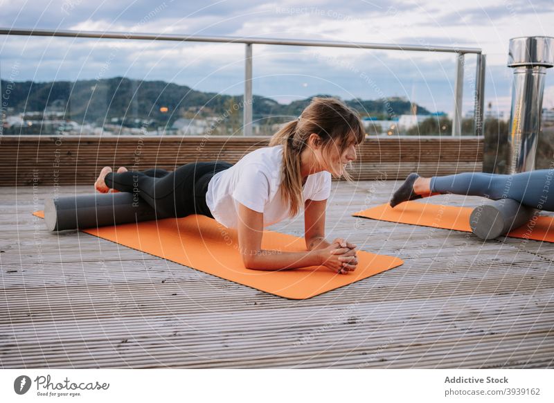 Frauen machen Yoga in High Cobra Posen auf der Terrasse üben Corba-Pose Asana beweglich Pilates schlank Unterlage Dehnung schäumen Rolle Wellness bhujangasana