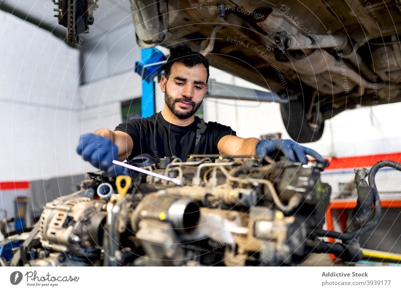 Männlicher Mechaniker repariert Auto in der Werkstatt Mann fixieren PKW Motor Dienst untersuchen Schraubenschlüssel männlich Techniker professionell Automobil