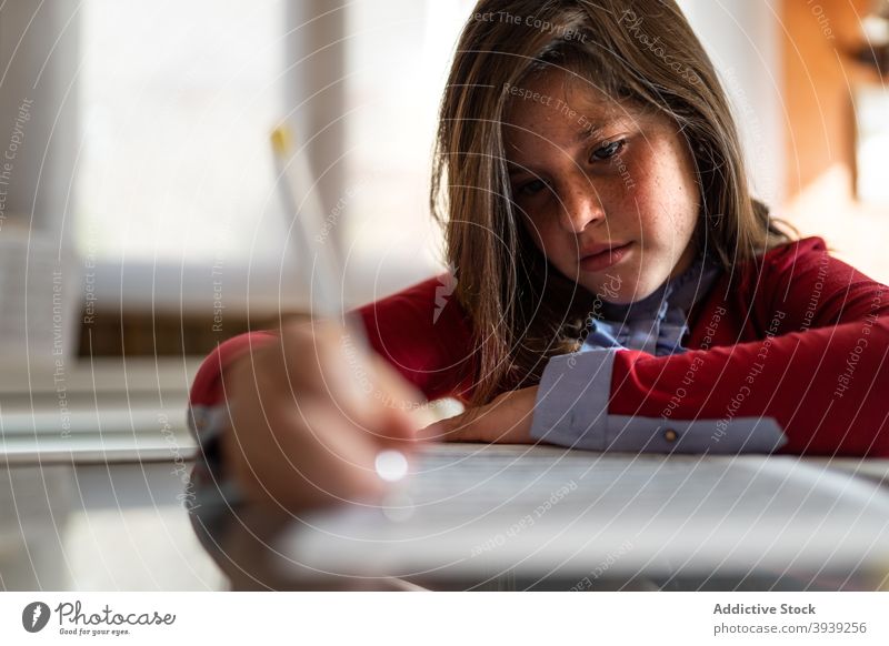 Konzentrierte Mädchen tun Hausaufgaben Aufgabe am Tisch schreiben Papier Konzentration Anweisung klug ernst Bildung Wissen Prüfungsvorbereitung Fokus Pupille