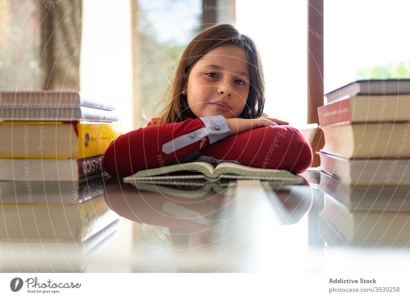 Adorable Kind Lesen Buch am Tisch zu Hause lesen Bildung lernen Hausaufgabe Anweisung sorgsam Lehrbuch Schulmädchen Pupille Leseratte Mädchen Haufen Wissen