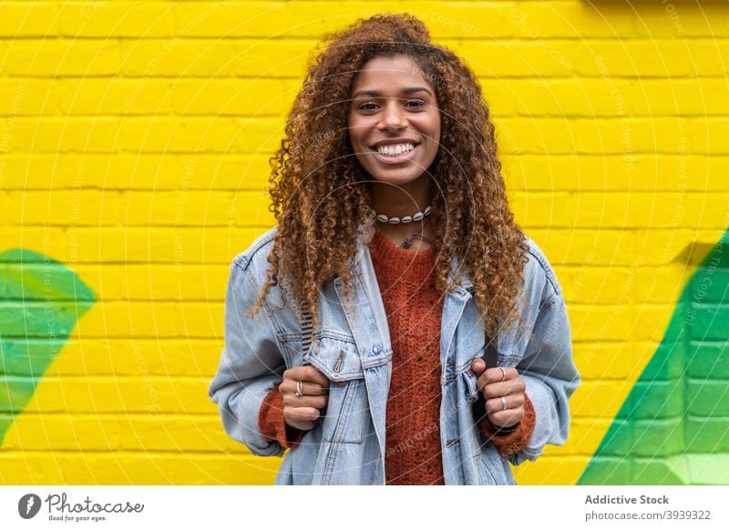 Fröhliche junge afroamerikanische Dame lächelt in die Kamera Frau Lächeln Optimist Stil Freude Straße positiv zufrieden heiter aufgeregt Vorschein
