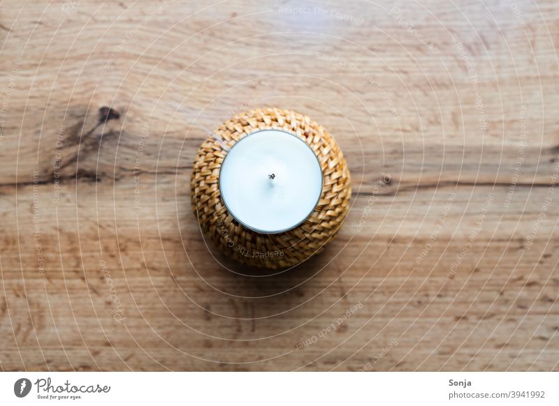 Eine ausgeblasene Kerze mit Rauch auf einem Holztisch. rustikal Innenaufnahme Wärme Kerzendocht heiß Wachs Trauer Teelicht gefährlich gemütlich geflochten