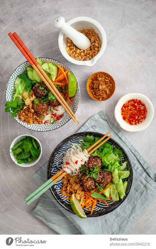 Ansicht von oben auf zwei vietnamesische Fadennudelschalen, Bun Cha, mit frischen vegetarischen Zutaten, Dip-Sauce, Erdnüssen und Röstzwiebeln Asien asiatisch