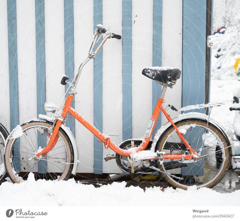 Klapprad im Winter Fahrrad Radfahren orange Schnee kalt Streifen retro Retro-Farben stylish