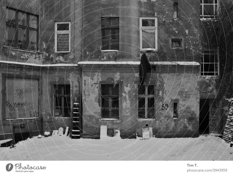 ein verschneiter alter Hinterhof in Prenzlauer Berg Berlin s/w b/w Winter Schnee Altbau Schwarzweißfoto Architektur b&w Fenster Außenaufnahme schwarz Tag
