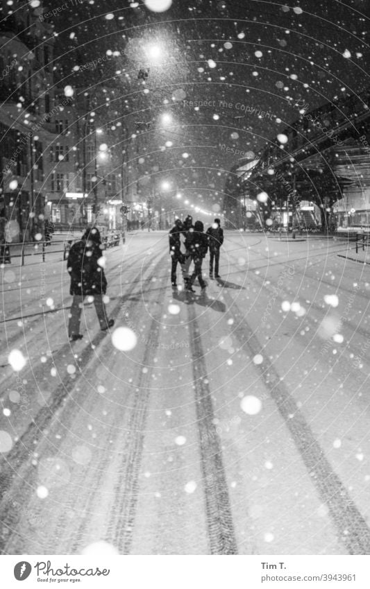 es schneit in der Schönhauser Allee Berlin s/w b/w Schnee Winter Straße Nacht night peoples Menschengruppe Schwarzweißfoto b&w Außenaufnahme Stadt dunkel