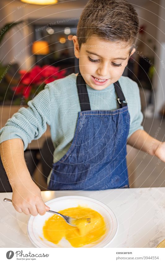 Kleiner Junge, der ein Ei in der Küche schlägt Aktivitäten backen schlagen schlagend Kekse Schalen & Schüsseln Kuchen Küchenchef Kind Kindheit Kinder Koch