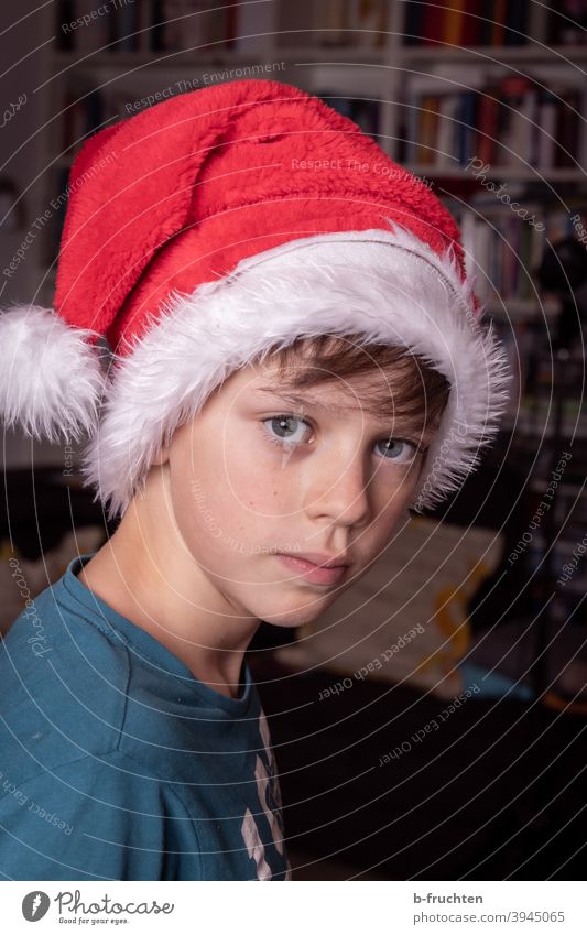 Kind mit Weihnachtsmütze Freude Mütze rot Weihnachten & Advent Feste & Feiern Nikolausmütze Farbfoto Innenaufnahme Kindheit Zimmer Junge skeptisch