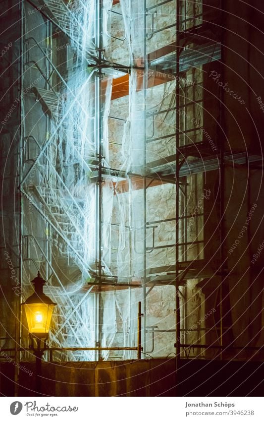 beleuchtetes Baugerüst an Kirche Baustelle Neonröhre Treppe Winter laterne nacht nachts Gerüst Fassade Menschenleer Gebäude Außenaufnahme Sanieren Architektur