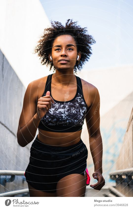 Afro-Athletin Frau läuft im Freien. Sport Übung Training Läufer Hintergrund Menschen Pflege Freizeit Körper Porträt Aktion Bewegung Herz trainiert. Motivation