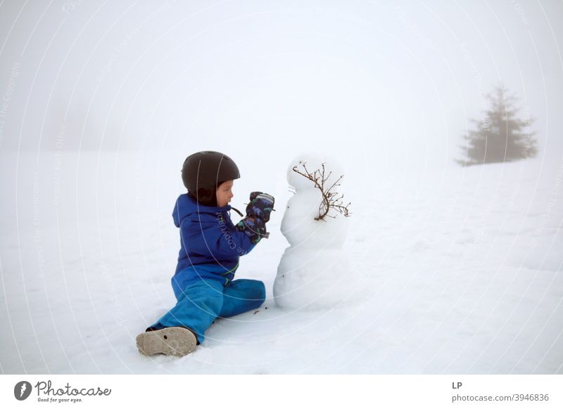 Kind macht einen Schneemann Porträt Außenaufnahme reizvoll emotional saisonbedingt Schneeflocke Feiertag Aktion machen Bekleidung Wetter Natur Winter