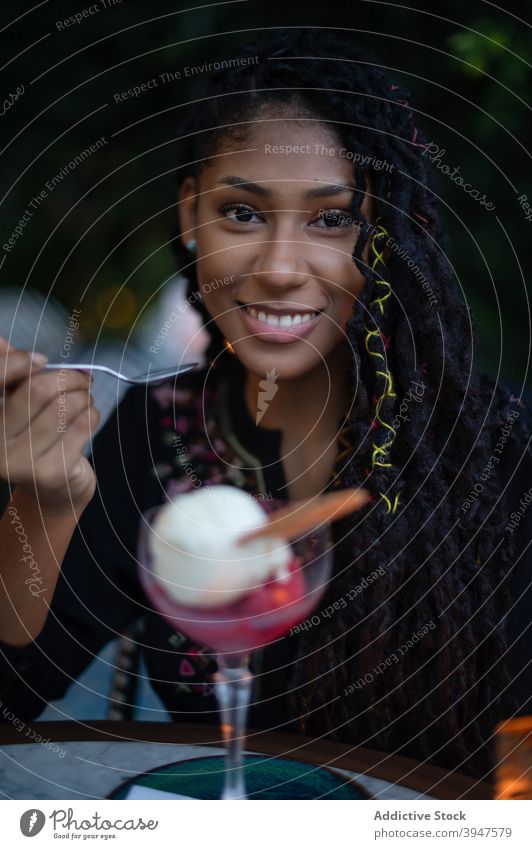 Afro latina Frau essen Eis im Restaurant Glück genießend Café Lächeln 20s jung Kolumbien lateinamerikanisch Afro-Look schwarz attraktiv dreads Lifestyle Essen