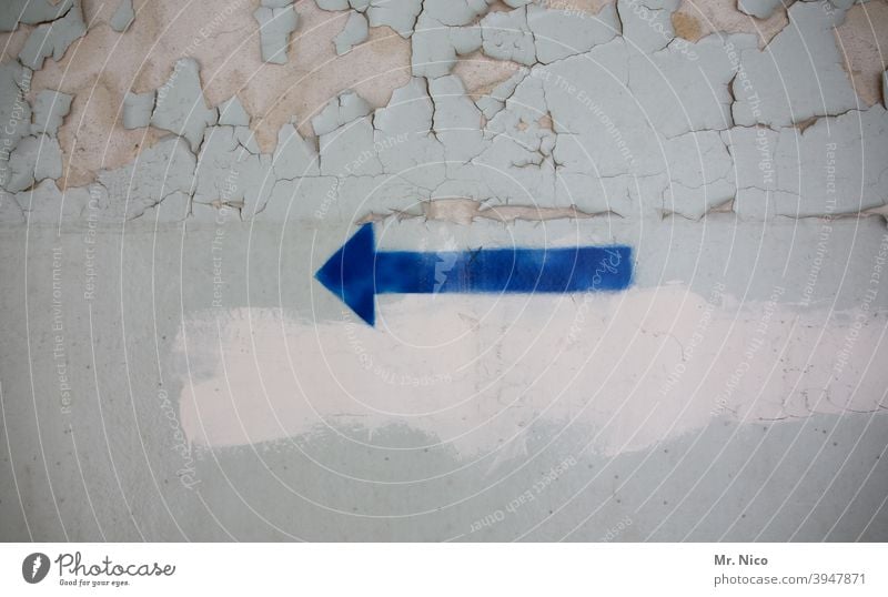 blauer Pfeil auf Wand Richtung richtungweisend Orientierung Zeichen Ziel nach links abblättern Mauer grau Renovieren dreckig Symbole & Metaphern Betonwand