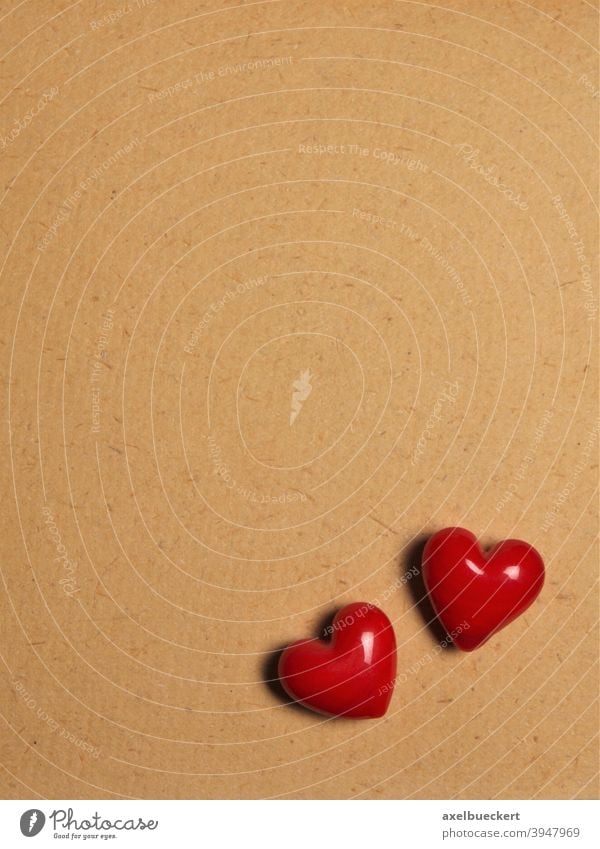 zwei rote Keramik Herzen auf Papier Hintergrund - Liebesbrief zum Valentinstag Brief Symbol Valentinsgruß braun Textur texturiert Textfreiraum romantisch