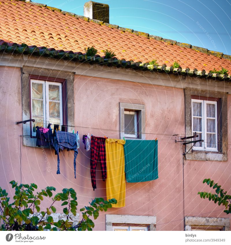 Altes Haus im mediteranen Stil mit Wäscheleine voller Wäsche. Fassade mit Dach und Fenstern bunt Himmel Wohnhaus trocknen Bekleidung Waschtag schönes Wetter