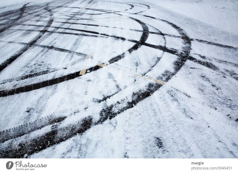 Reifenspuren auf einer glatten Straße mit Schnee und Eis asfaltstraße glatteis Spuren Gedeckte Farben Detailaufnahme Muster Dämmerung Linie Autofahren Glätte