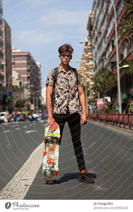 Porträt von jungen Skateboarder Mann mit Bad Boy Gesicht in der Mitte der Straße. Typ Skateboarderin urban Model retro Einstellung Aussehen Starrer Blick Plakat