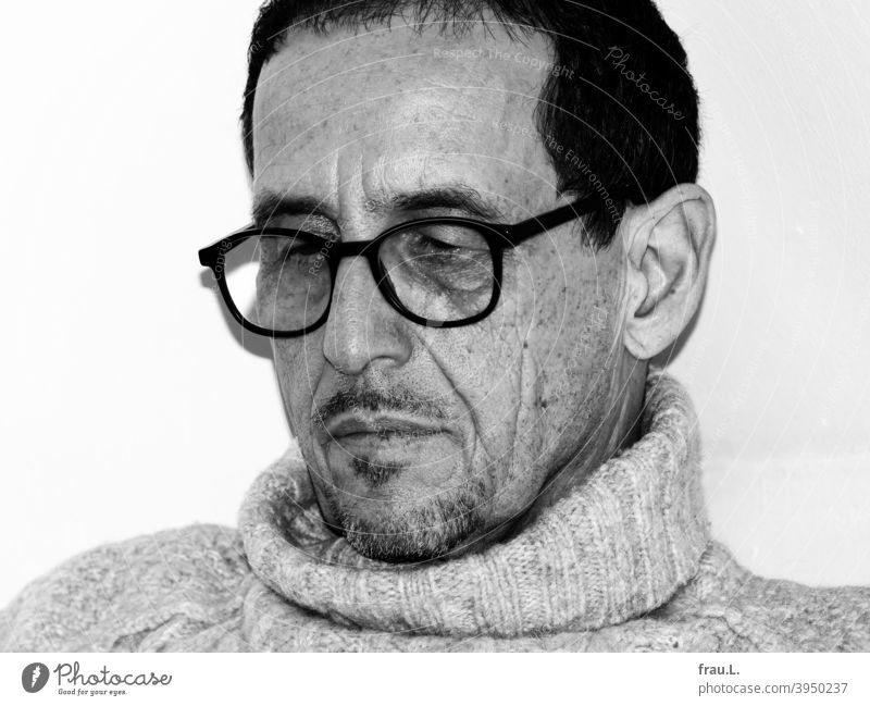Ein lesender Mann Bart Falten Porträt Gesicht Brille sitzen Pullover Rollkragenpullover Blitzlicht