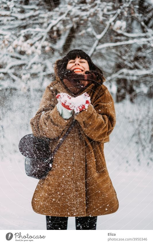 Schneeverliebt im Winter - Eine junge Frau steht im Schnee und lacht vor Freude lachen winterlich brünett Lebensfreude Schneelandschaft verschneit spielen