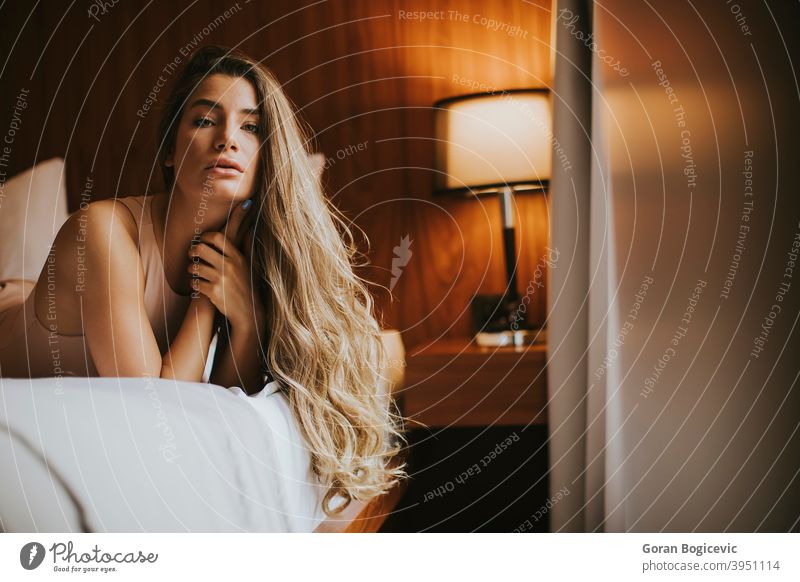 Schöne junge Frau liegt auf einem Bett am Morgen 20s Erwachsener Appartement attraktiv schön Schönheit Schlafzimmer lässig Kaukasier bequem niedlich heimisch
