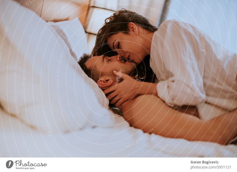 Schönes junges liebendes Paar im Bett liegend Erwachsener attraktiv Schlafzimmer Kaukasier umarmend gutaussehend Fröhlichkeit Glück heimwärts horizontal
