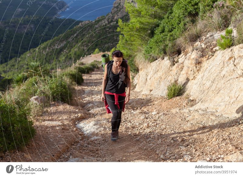Aktiver junger weiblicher Wanderer, der beim Trekking in den Bergen einen felsigen Pfad entlang läuft Frau Spaziergang Nachlauf Berge u. Gebirge Wanderung