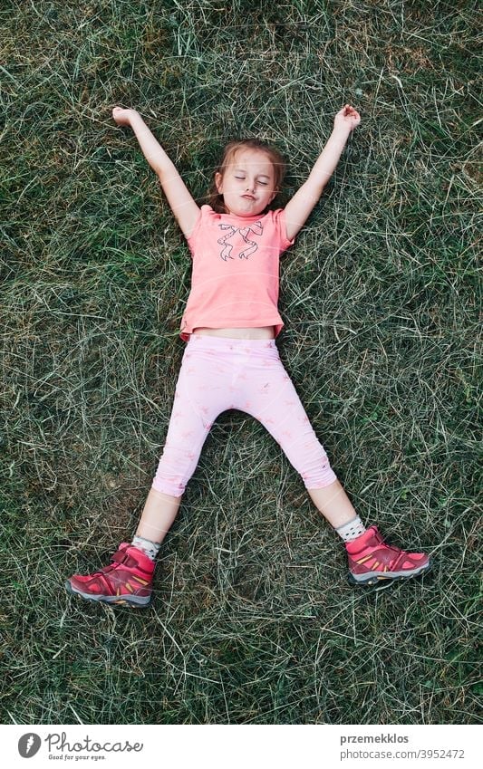 Kleines Mädchen liegend spielen auf Gras genießen Sommertag während Urlaub Reise Glück Aufregung Genuss Freizeit Ausflug Spielen Emotion positiv Lügen Lifestyle