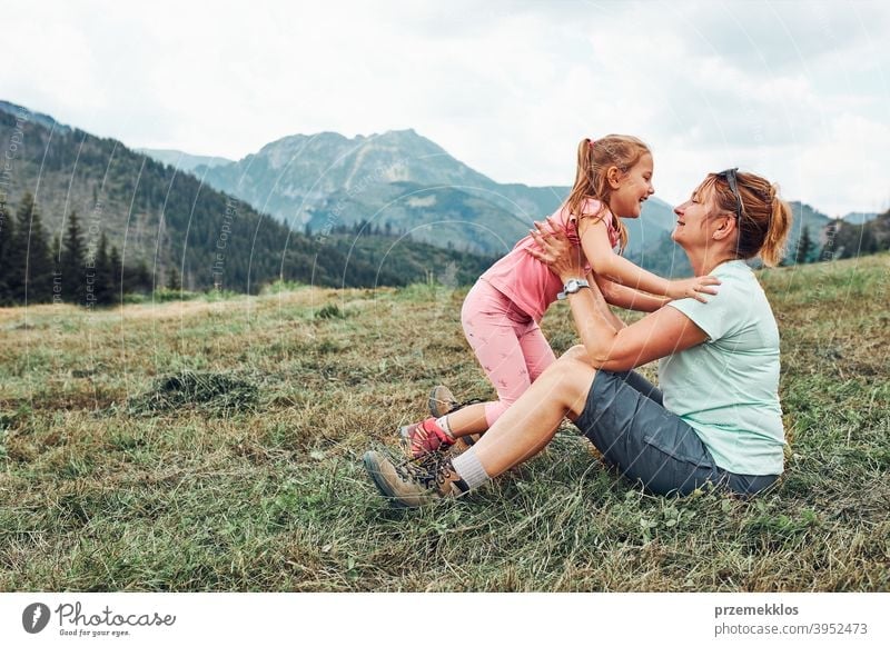 Kleines Mädchen spielt mit ihrer Mutter auf Gras genießen Sommertag während der Urlaubsreise in den Bergen Glück Aufregung Genuss Freizeit Ausflug Spielen