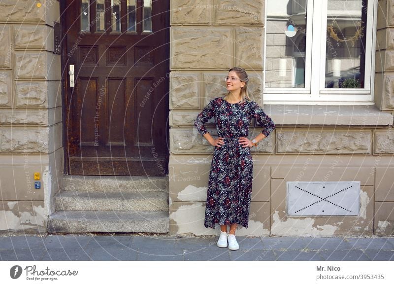 Junge Frau im Sommerkleid steht vor einer Hausfassade feminin Hauseingang Mode stehen selbstbewußt Coolness Gelassenheit Porträt Vorderansicht Gebäude Fassade