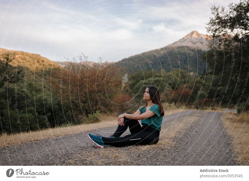 Junge Frau rastet auf der Straße beim Wandern im Hochland Reisender Berge u. Gebirge ruhen sich[Akk] entspannen Freiheit Wanderung Abenteuer Natur jung Spanien