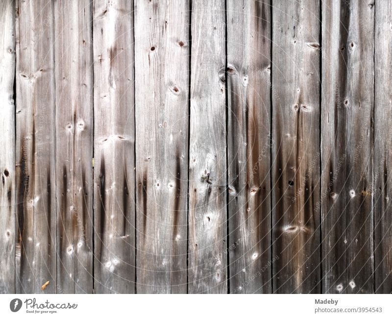Schönes braunes altes Holz mit Maserung und Astlöchern einer Hütte auf einem Bauernhof in Oberbayern Fassade Brett Astloch Handwerk Tradition Tischler Bayern