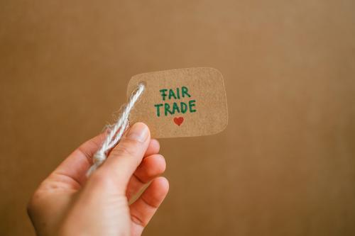 Hand hält ein Etikett auf dem Fair Trade geschrieben steht. Fair gehandelte Waren kaufen. Fair trade fair gehandelt bewusster Konsum fairtrade Verantwortung