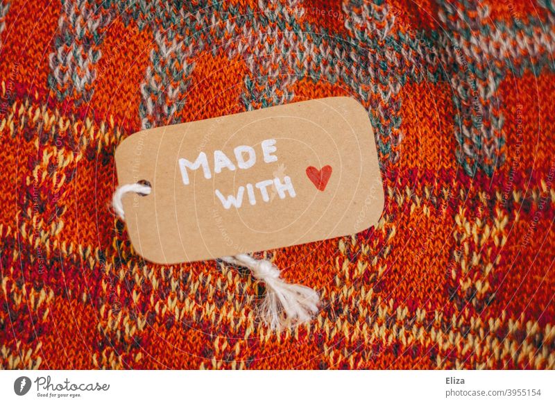 Ein Etikett mit der Aufschrift "Made with Love" auf einem selbstgestrickten Kleidungsstück Made with love handgemacht Strickware liebevoll lokal einkaufen