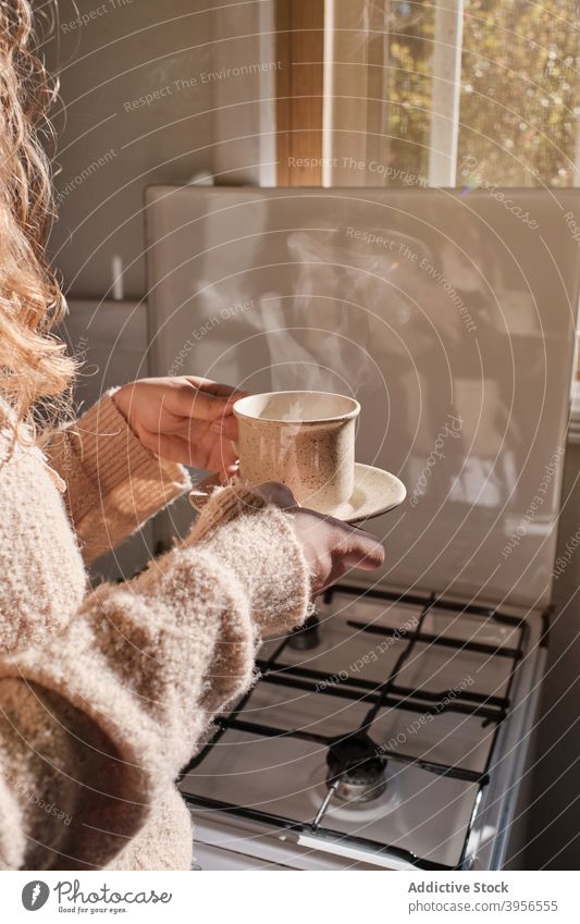 Anonyme Frau mit Tasse Getränk zu Hause heiß trinken Morgen genießen heimwärts sich[Akk] entspannen Kaffee Tee ruhen gemütlich Becher Untertasse Frühstück