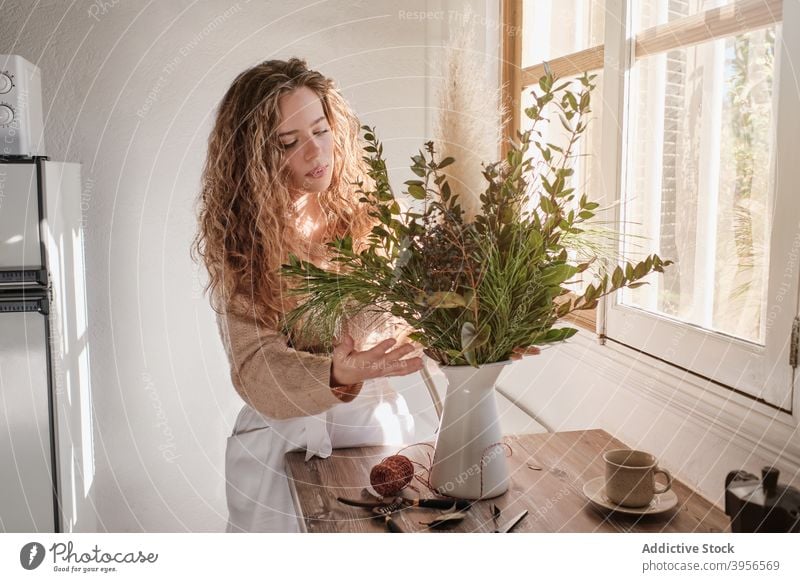 Frau arrangiert Pflanzen in Vase Haufen Blumenstrauß frisch sanft Flora Floristik heimwärts Tisch grün Stil natürlich Harmonie Dekor organisch romantisch