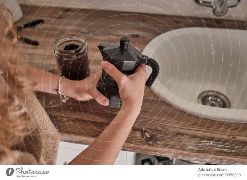 Crop Frau bereitet Kaffee in der Küche Geysir Kaffeemaschine trinken heimwärts heimisch Boden vorbereiten selbstgemacht Energie Tisch Moka-Topf Getränk