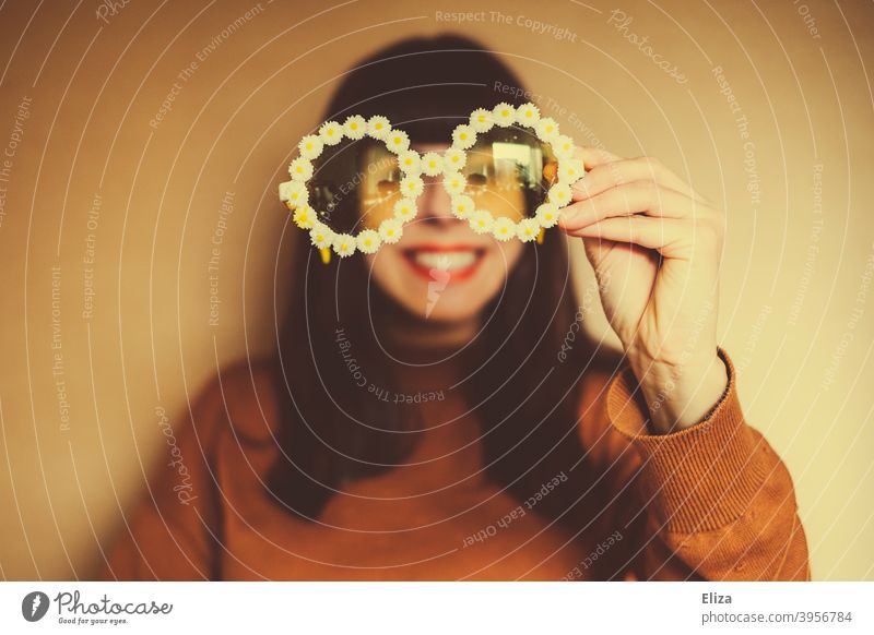 Frau mit Blümchen-Sonnenbrille. Retrostimmung, Optimismus und gute Laune. Sommerstimmung farbenfroh gelb orange Portrait Vitamin D Sonnenlicht knallig