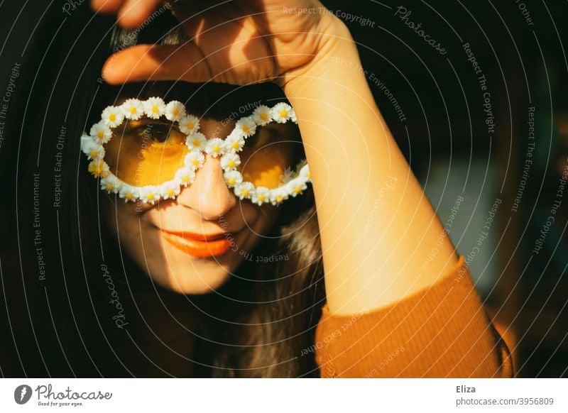 Junge Frau mit retro Blümchensonnenbrille im Sonnenschein Sonnenbrille warm Hippie gute Laune fröhlich verrückt Sommer sommerlich Wärme Gänseblümchen Blumen