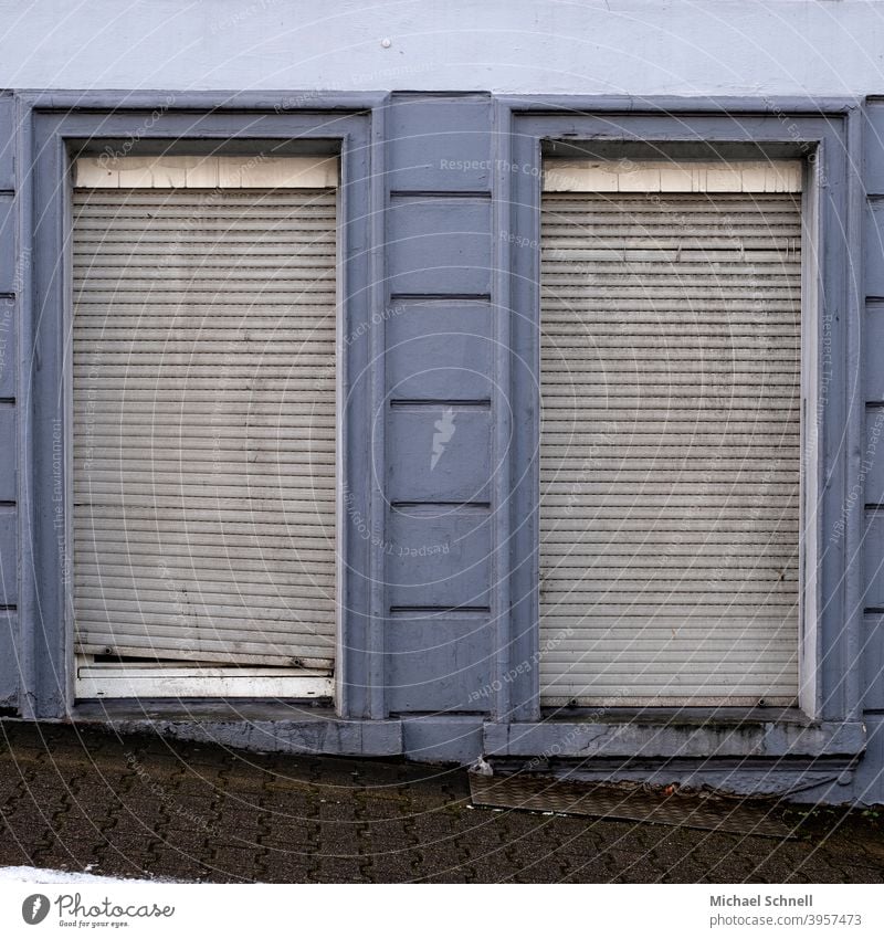 Alte, graue Rolladen an einem alten Haus blau geschlossen Fenster Fassade trist Wand Menschenleer Rollladen Verfall