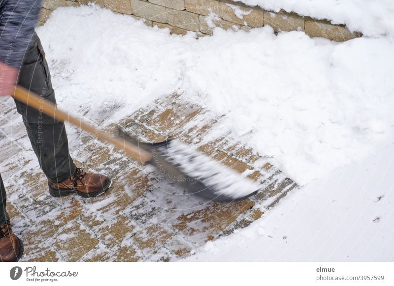 Schneeschippen - ein Mann befreit mit einem Schneeschieber den Weg vom Neuschnee / Bewegungsunschärfe Einfahrt Person Dienstleistung Garageneinfahrt schneefrei