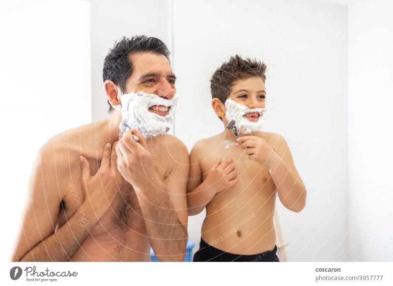 Lustiger Vater und Sohn beim Rasieren im Bad Erwachsener Bonden Junge Kind Kindheit Sahne Papa Papi Tag elementar Gesicht Familie Vaterschaft schäumen Spaß