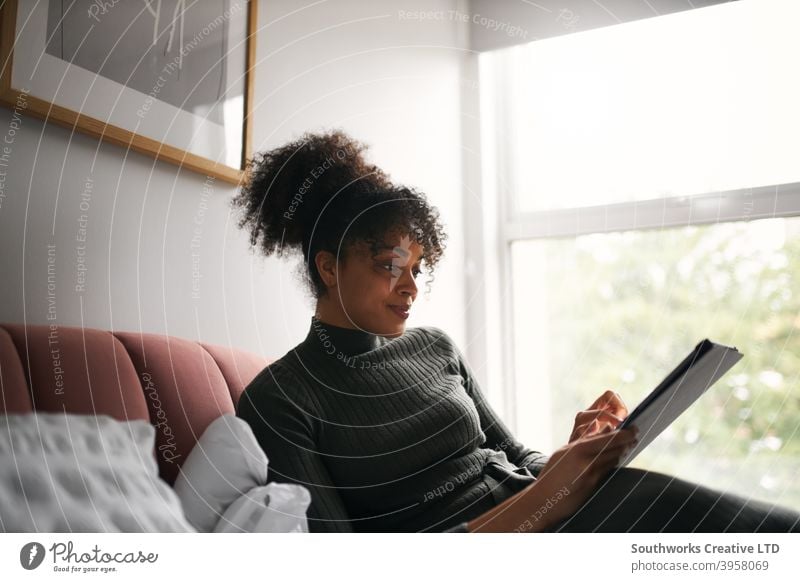 Frau entspannt auf dem Bett zu Hause lesen oder Streaming-TV-Show auf digitalen Tablet digitales Tablett Tablet Computer E-Book zuschauend FERNSEHER