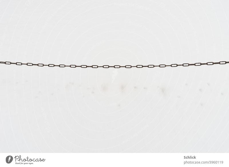 Eisenkette vor Schnee schneefläche dünn Kette Metall Farbfoto Außenaufnahme Menschenleer Tag Verbundenheit Verbindung Zusammenhalt minimalistisch