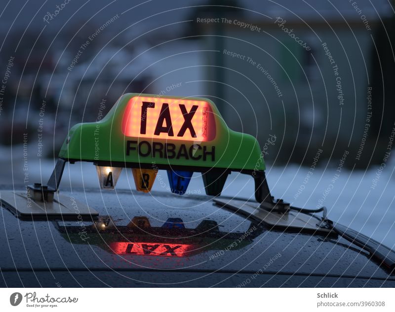 Defekte Leuchte auf einem Taxi aus Forbach Lothringen mit Aufschrift rax oder tax und Spiegelung im regennassen Blechdach Taxischild Regenwetter defekt Text