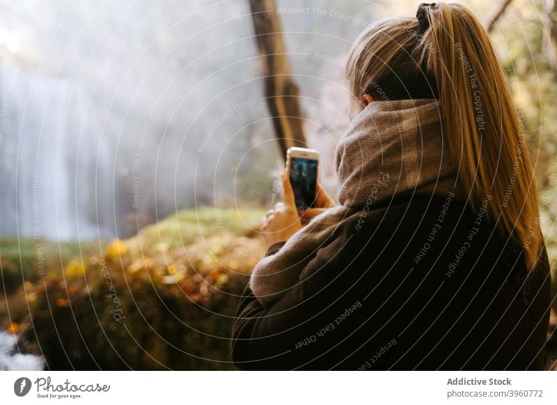 Frau mit Smartphone im Wald in der Nähe von Wasserfall fotografieren Herbst Gedächtnis Natur Wälder Foto Apparatur Gerät Telefon fallen Funktelefon Saison