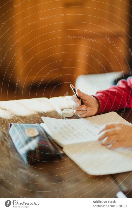 Kind macht Hausaufgaben am Tisch schreiben Schulkind Anweisung Bildung lernen Bleistift Hand Schönschreibheft Wissen Aufgabe Pupille sorgsam klug