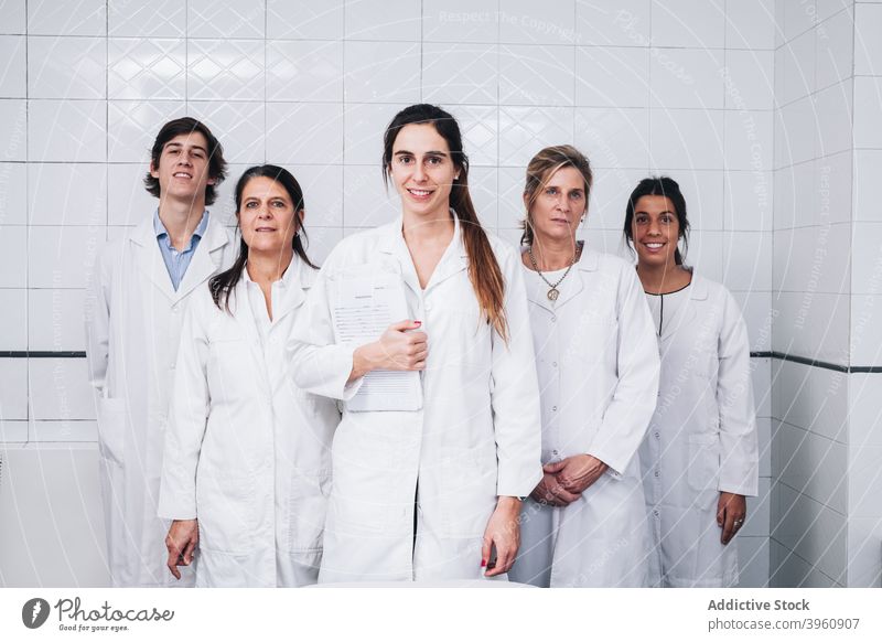 Eine Gruppe Ärzte in weißen Kitteln steht, während einer von ihnen einen Bericht hält crotochisch Analyse Analysieren durchsetzungsfähig Überprüfung Klinik