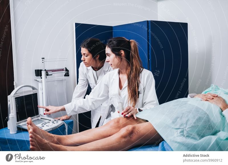 Ärzte machen eine Ultraschalluntersuchung an den Beinen eines Patienten crotochisch Analyse Analysieren Anatomie Knochen Überprüfung Klinik Mantel Kollegen